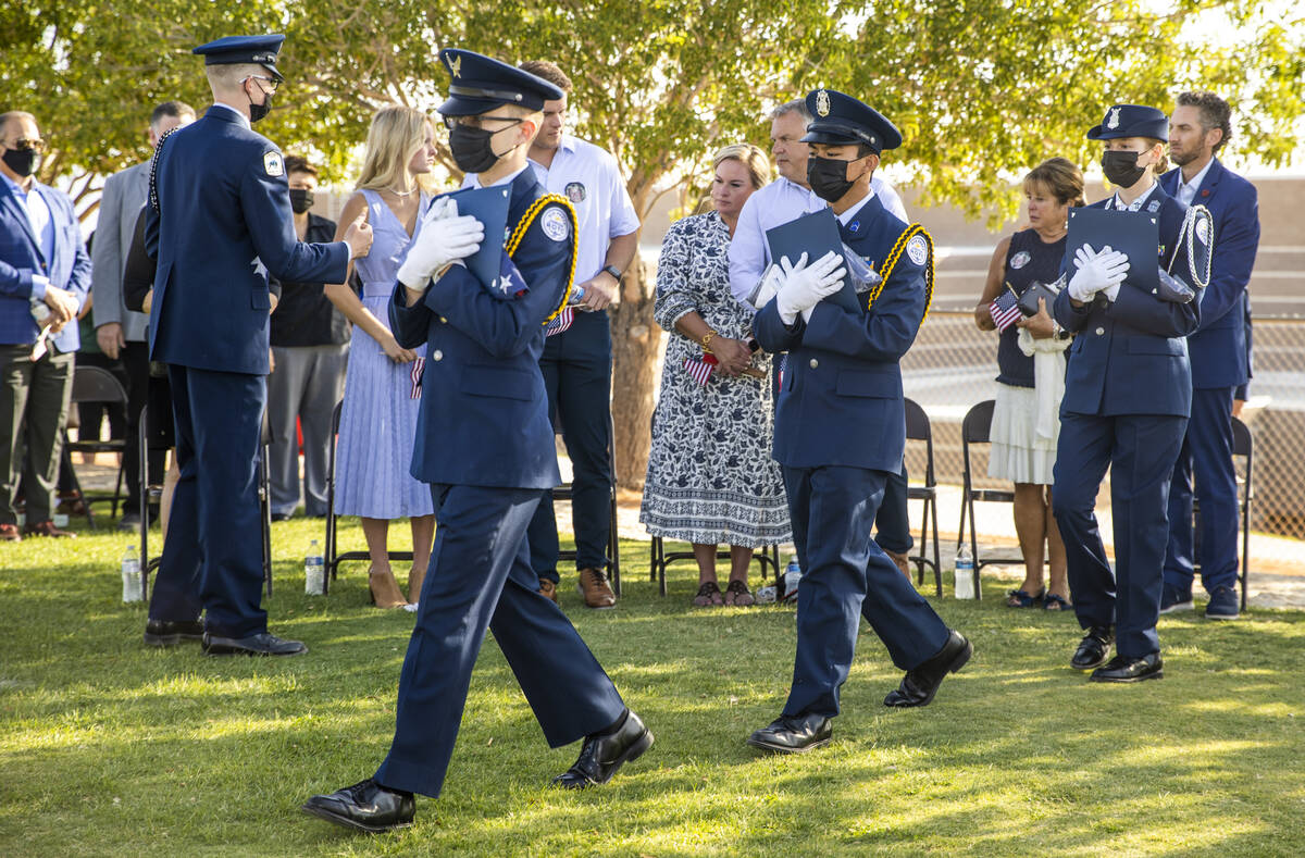 Air Force JROTC cadets carry in ceremonial flags for family members during a ceremony to honor ...