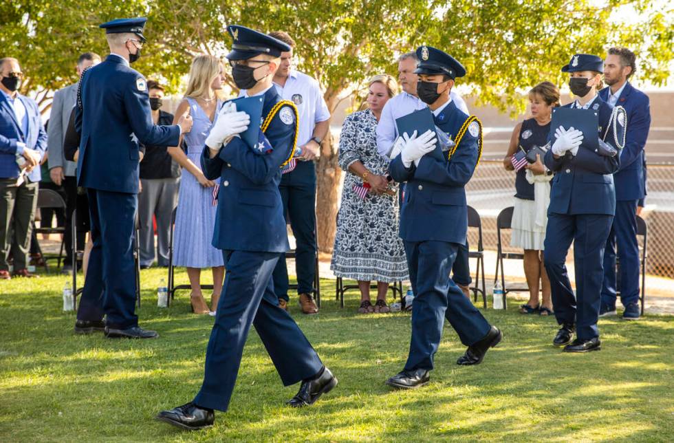 Air Force JROTC cadets carry in ceremonial flags for family members during a ceremony to honor ...