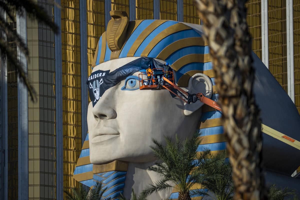 A team from Access Solutions hangs a Raiders eye patch on the Great Sphinx of Giza replica outs ...