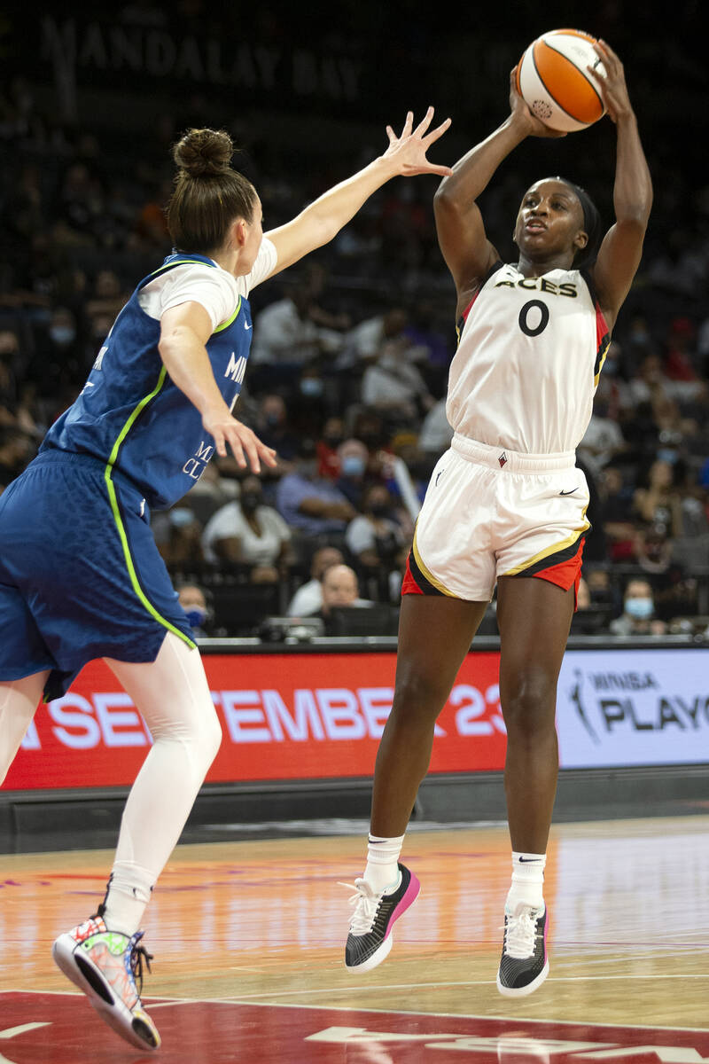 Las Vegas Aces guard Jackie Young (0) shoots a three-pointer guarded by Minnesota Lynx forward ...