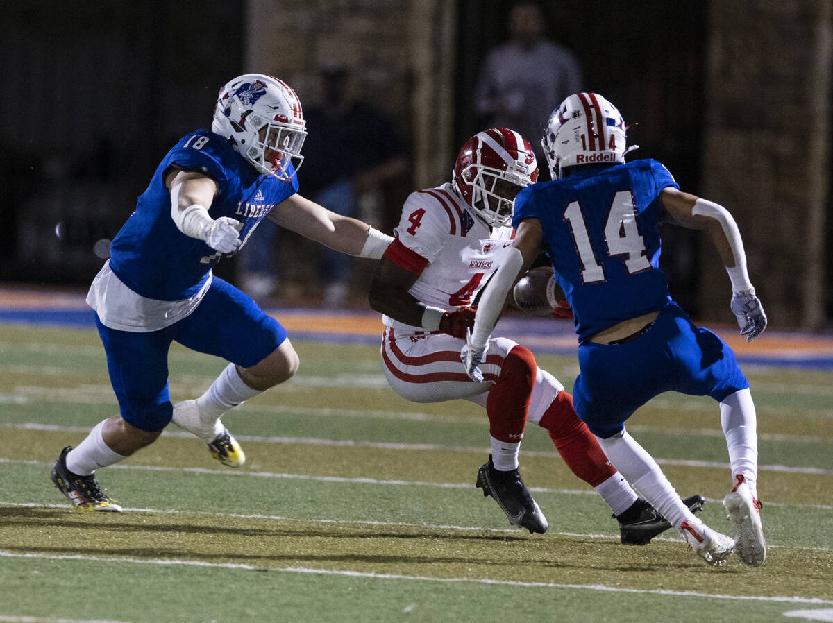 Liberty linebacker La'akea Louis (18) and center back Isaiah Hampton (14) defend Mater Dei runn ...