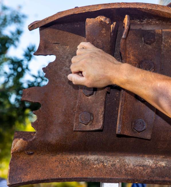 An attendee touches a piece of World Trade Tower steel on display, Saturday, Sept. 11, 2021, at ...