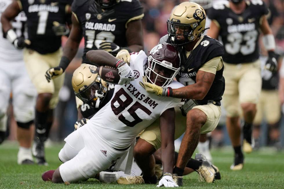 Texas A&M tight end Jalen Wydermyer, left, is tackled by Colorado cornerback Christian Gonz ...