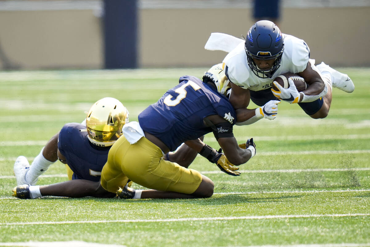 Toledo running back Micah Kelly, right, is tackled by Notre Dame cornerback Cam Hart (5) in the ...