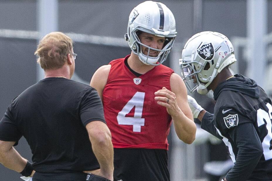 Raiders quarterback Derek Carr (4) meets with head coach Jon Gruden, left, and Raiders running ...