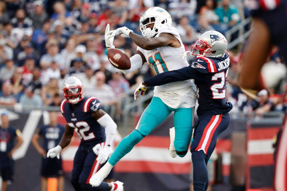 New England Patriots defensive back J.C. Jackson, right, breaks up a pass to Miami Dolphins wid ...