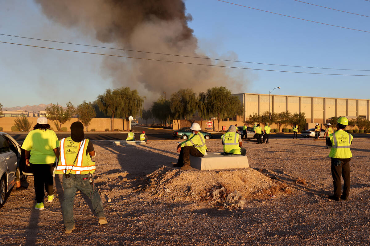 Workers wait as the North Las Vegas Fire Department battles a fire at a Republic Services recyc ...