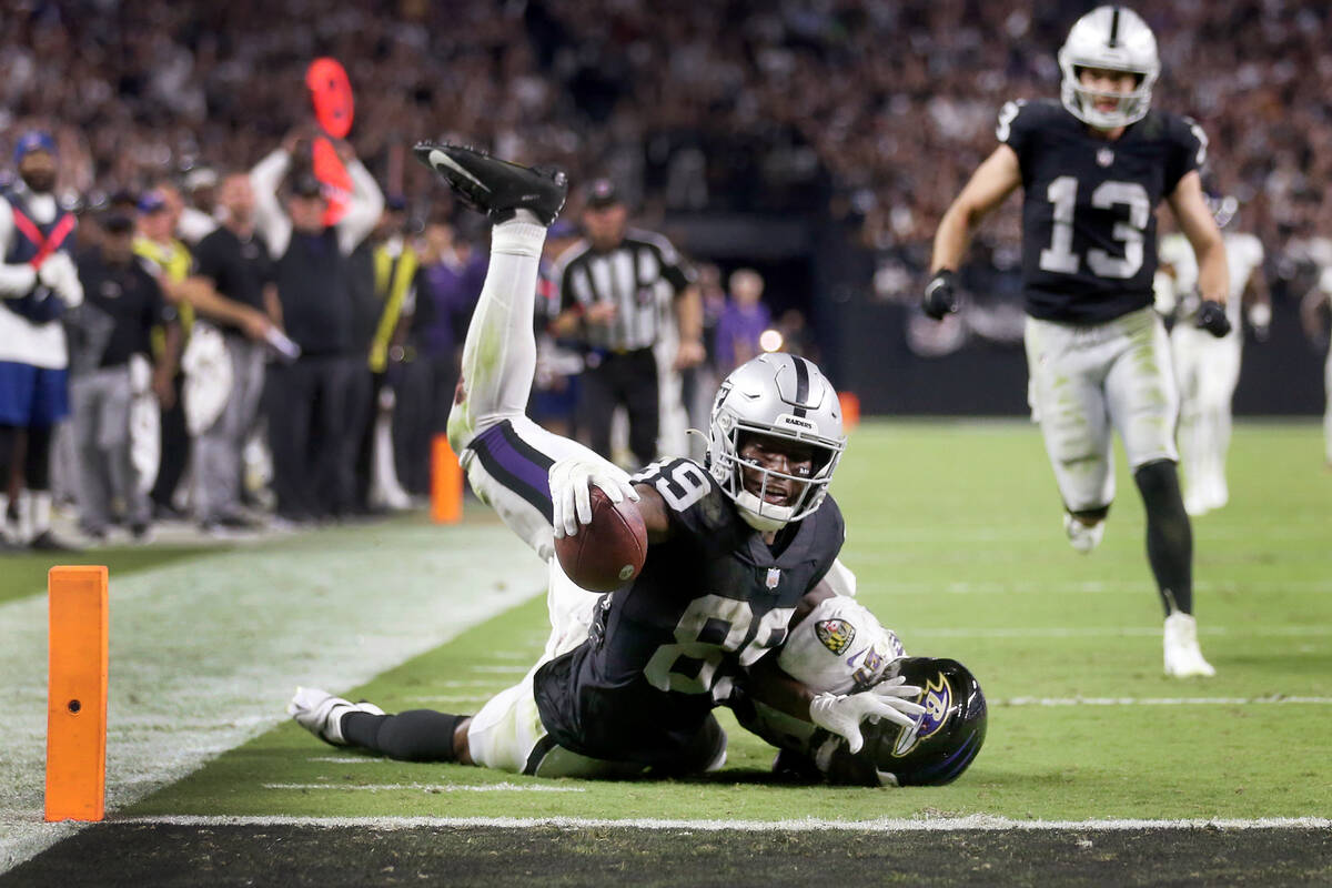 Raiders wide receiver Bryan Edwards (89) reaches short of a touchdown while getting tackled by ...