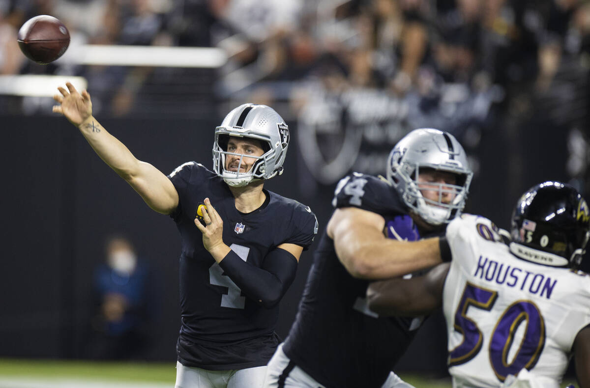 Raiders quarterback Derek Carr (4) makes a pass over Baltimore Ravens linebacker Justin Houston ...