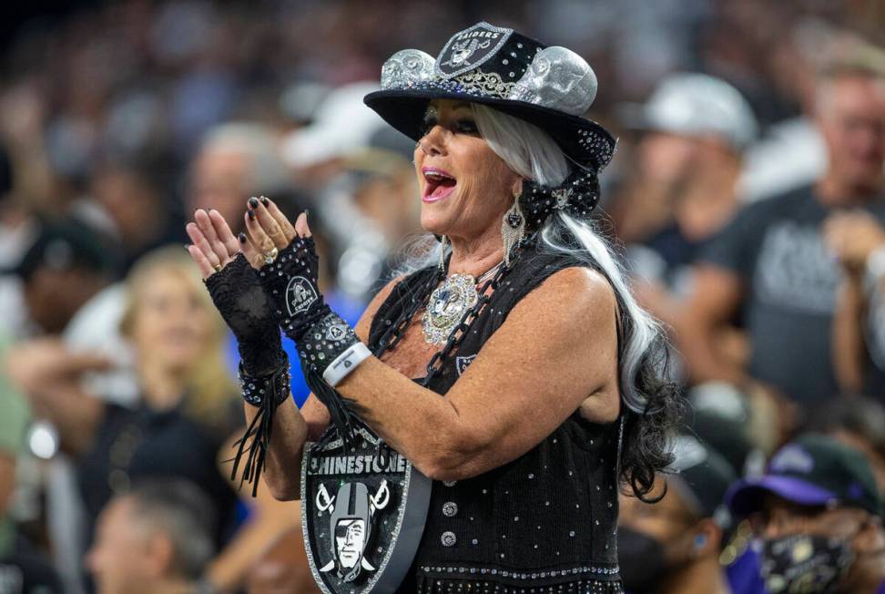 A Raiders fan cheers during the first quarter of an NFL football game against the Baltimore Rav ...