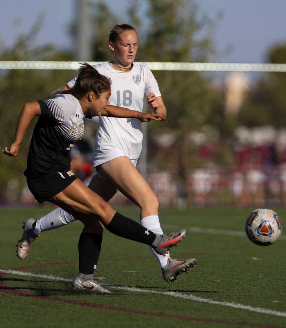 Faith Lutheran’s Mia Coe (13) shoots on goal with Arbor View’s Alexis Romeo (18) ...