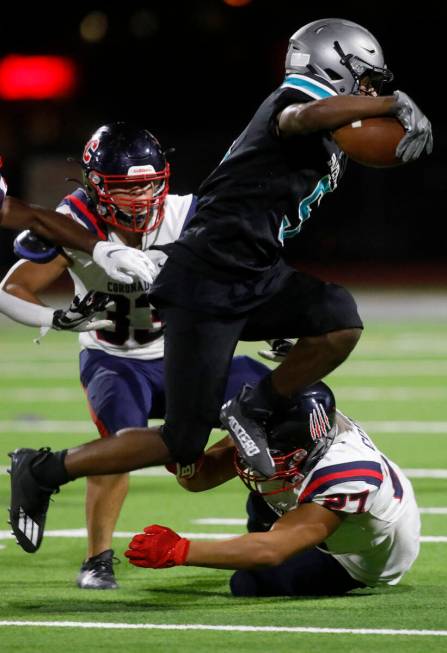 Silverado High School's Jaden Thrower (5) jumps over Coronado High School's Mohammad Maali (27) ...