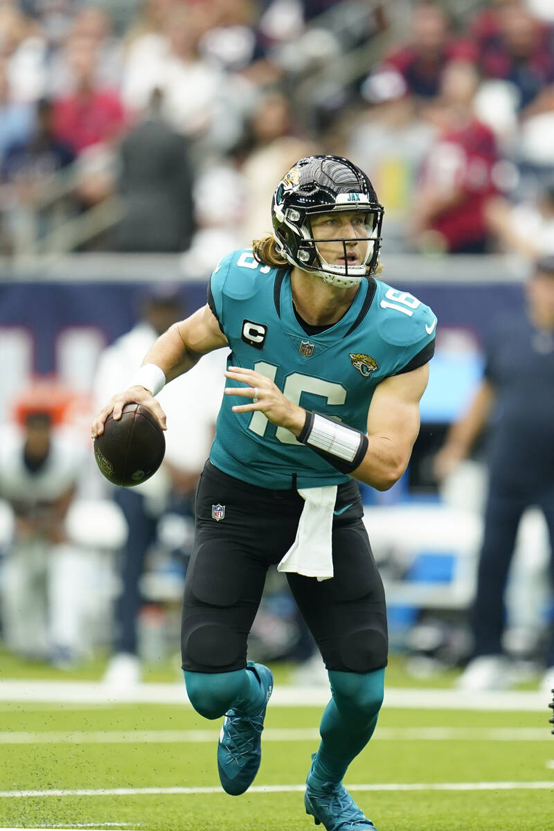 Jacksonville Jaguars quarterback Trevor Lawrence (16) rolls out as he looks to pass during an N ...