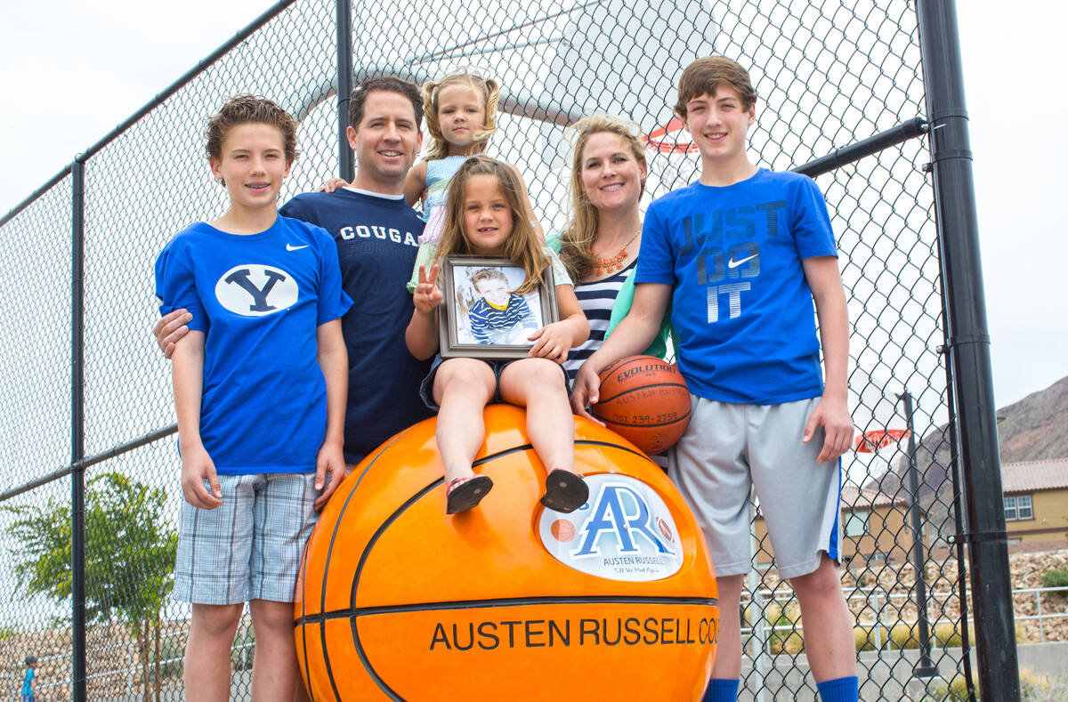 Kyler, Troy, Maddie, Payton, Deedra and Collin Russell with photo of Austen Russell, 9, stand n ...