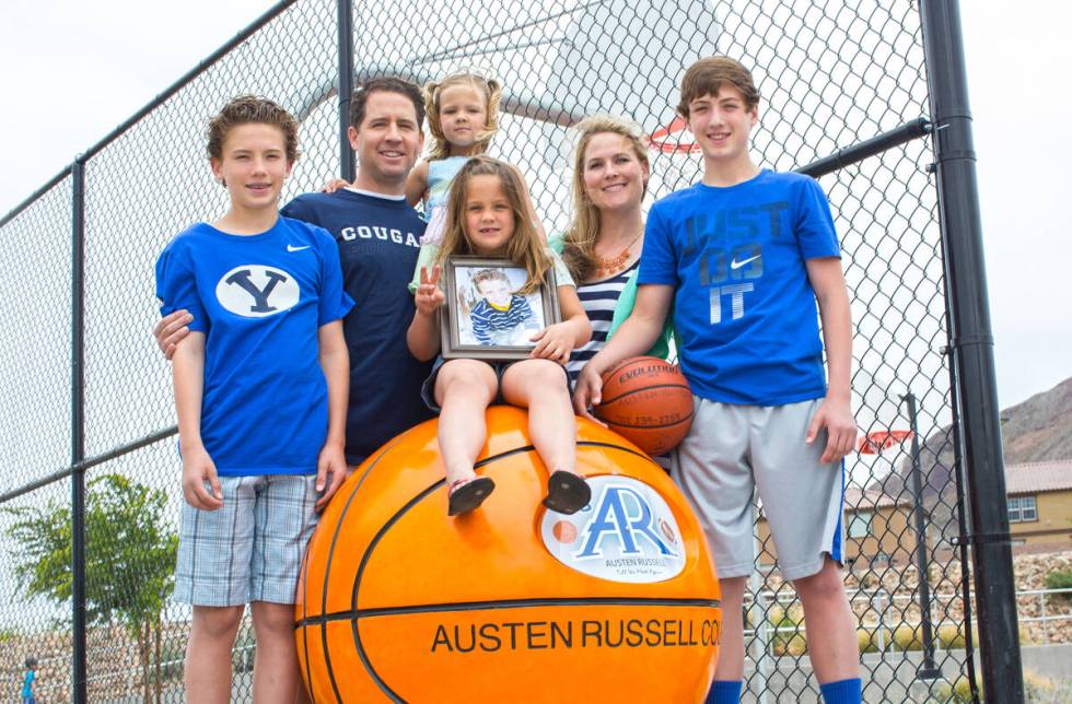 Kyler, Troy, Maddie, Payton, Deedra and Collin Russell with photo of Austen Russell, 9, stand n ...