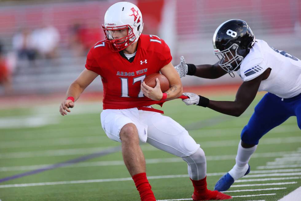 Arbor View's Kyle Holmes (17) is tackled by Desert Pines Labarrio Mays (8) in the first half of ...