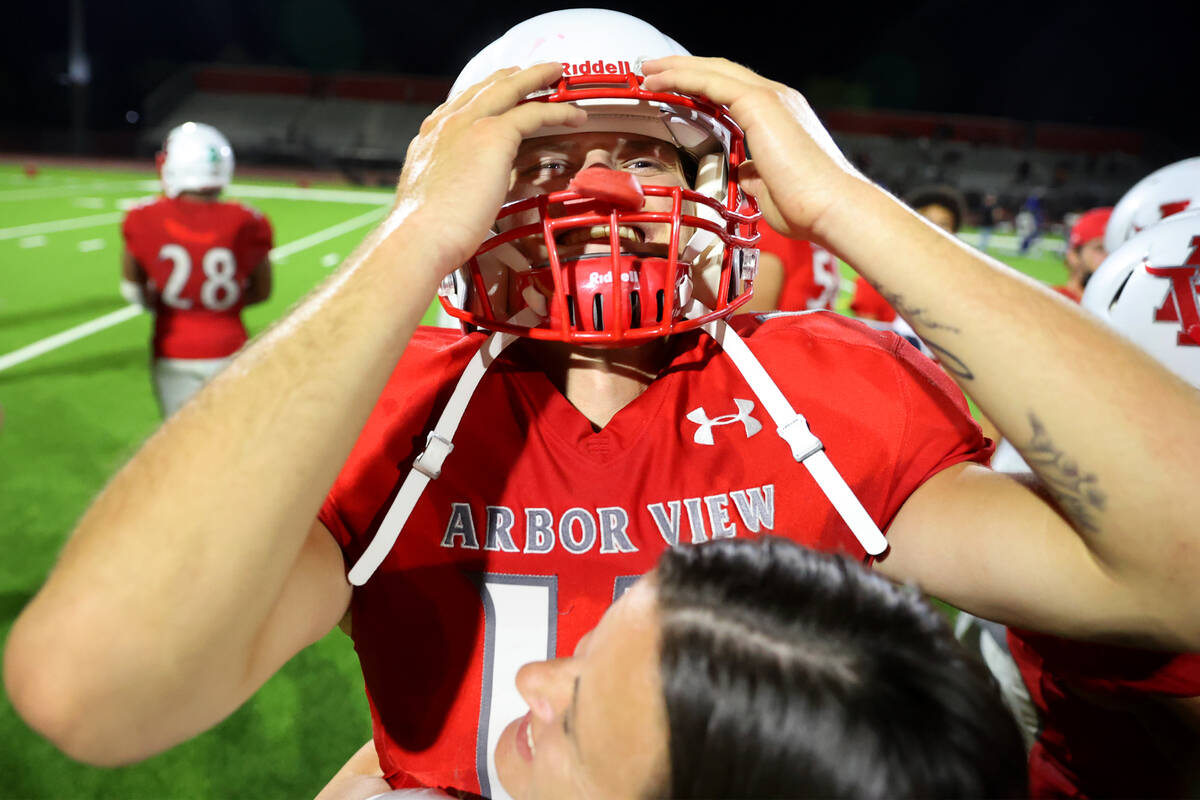 Arbor View's quarterback Kyle Holmes (17) receives a hug from his mother Jessica Holmes after d ...