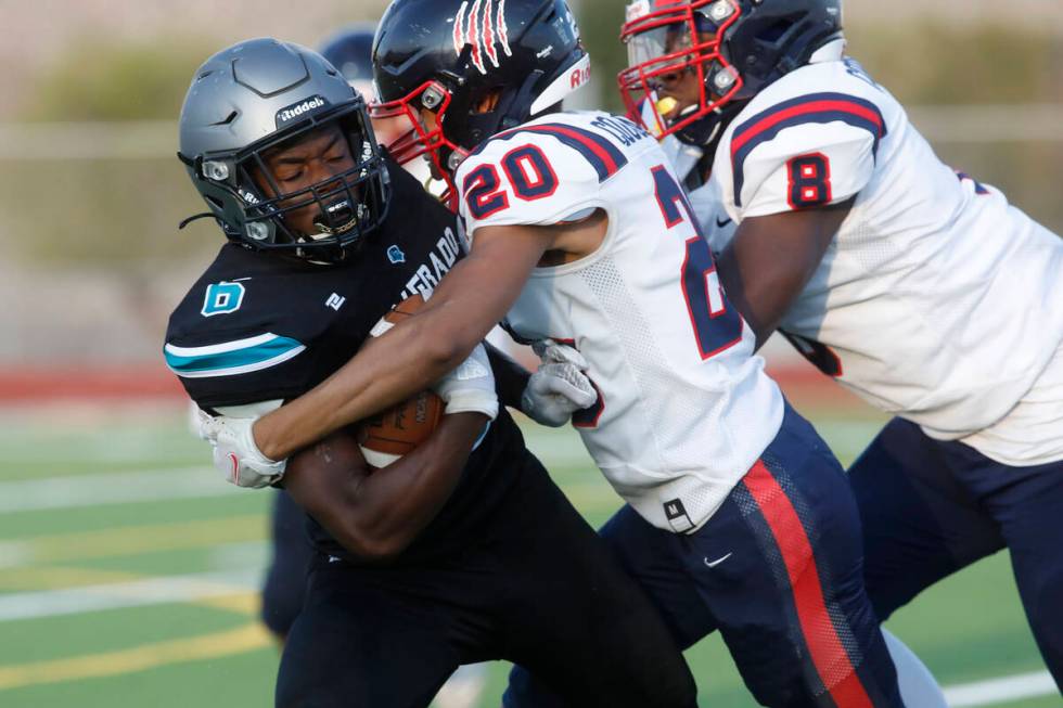 Silverado High School's John Agounke (6) is tackled by Coronado High School's Preston McQueen ( ...