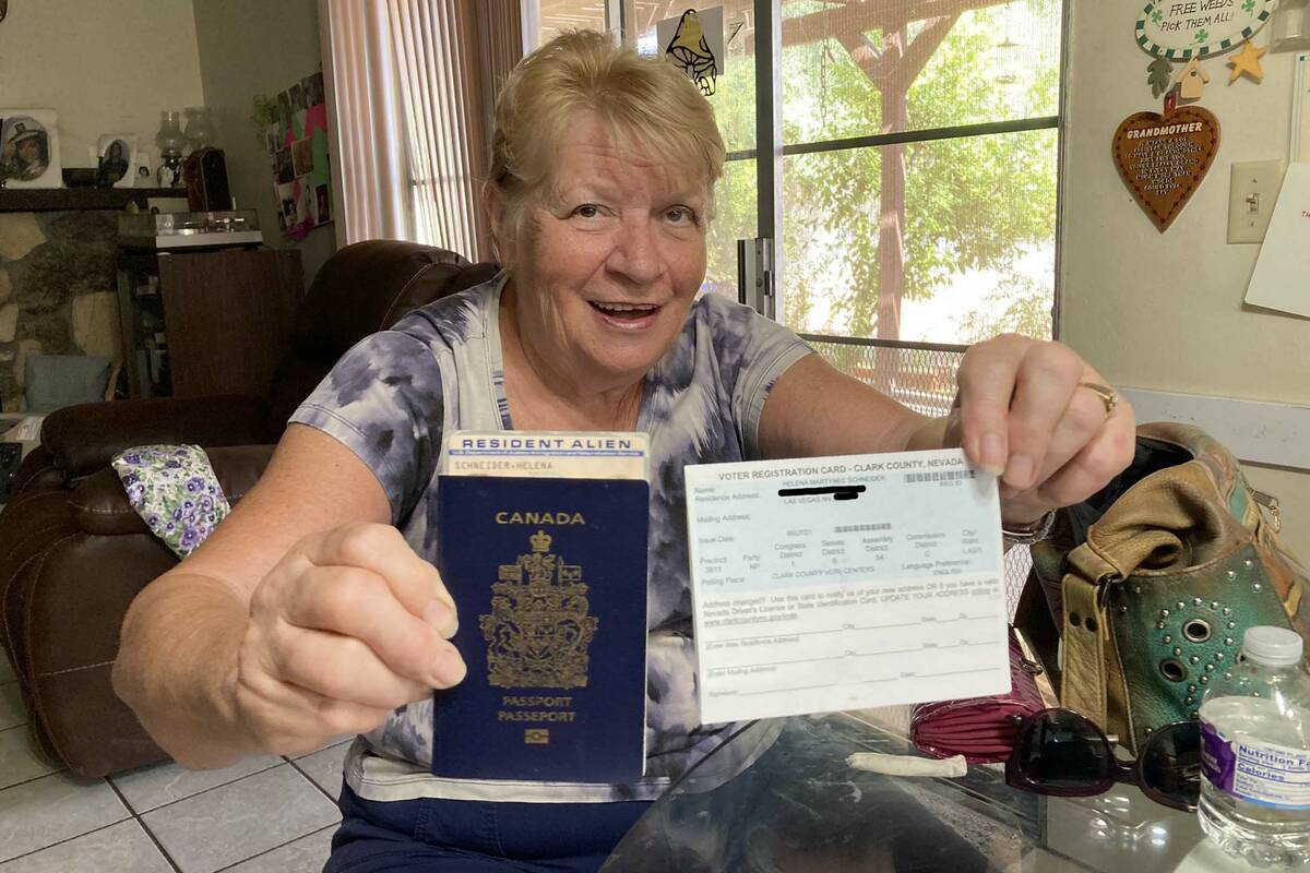 Helena Schneider holds up her Canadian passport, resident alien card and Nevada voter registrat ...
