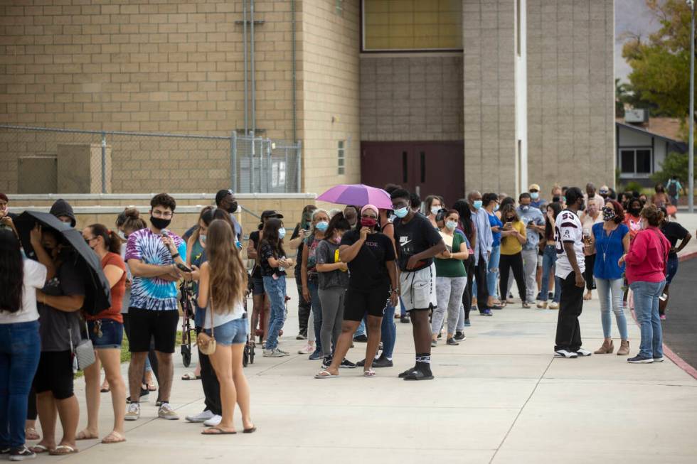 People line up during a pop-up COVID-19 vaccination clinic at Eldorado High School in Las Vegas ...