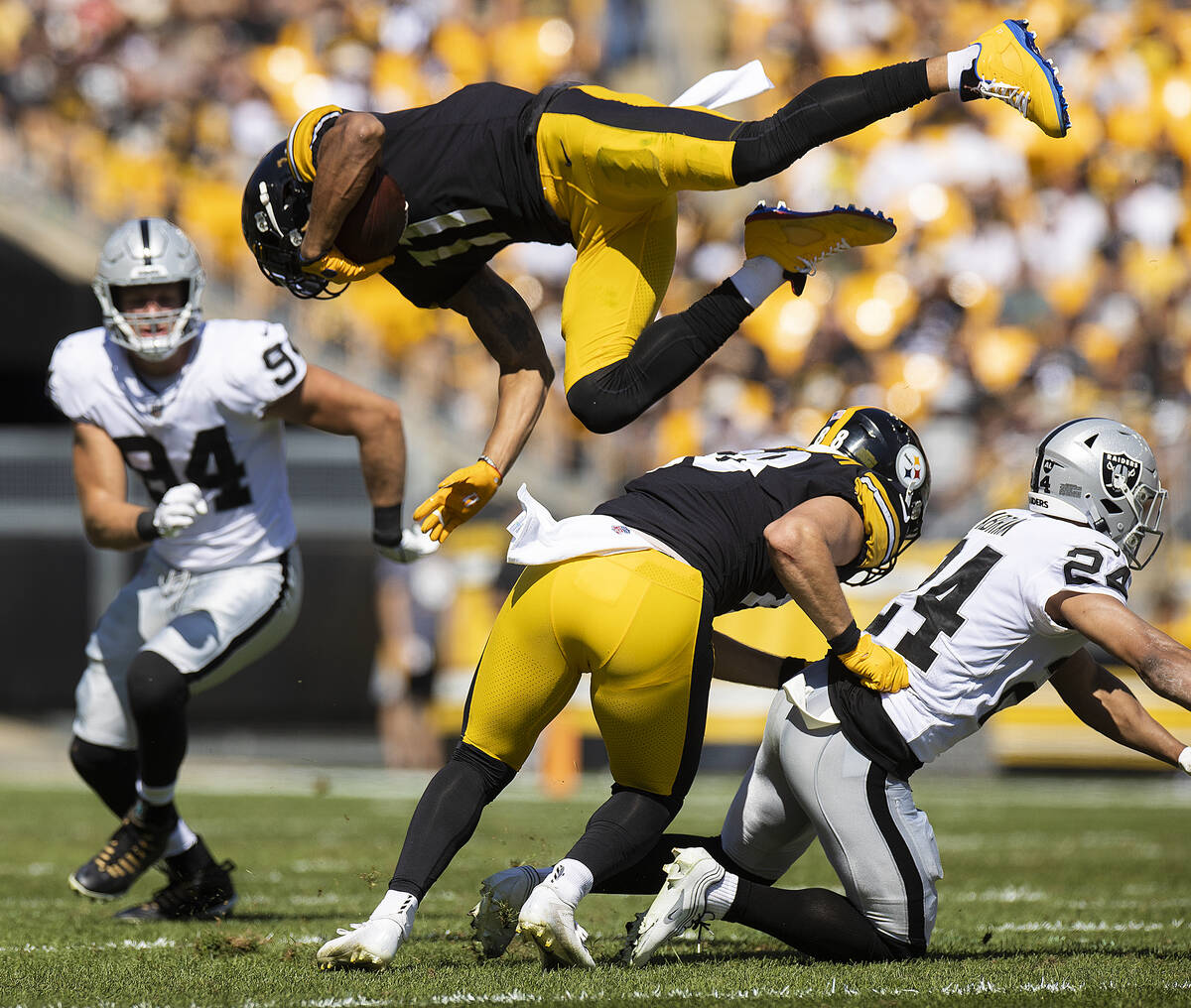 Pittsburgh Steelers wide receiver Chase Claypool (11) is up ended by Raiders defensive back Joh ...