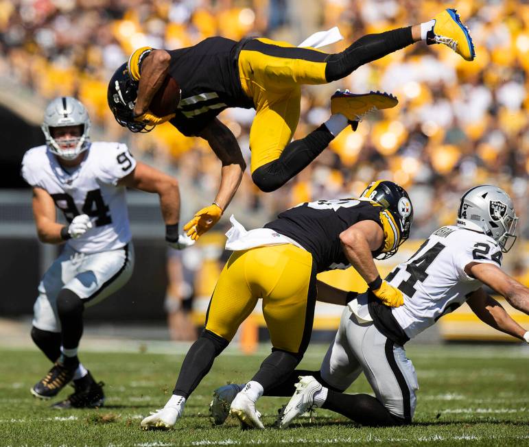 Pittsburgh Steelers wide receiver Chase Claypool (11) is up ended by Raiders defensive back Joh ...