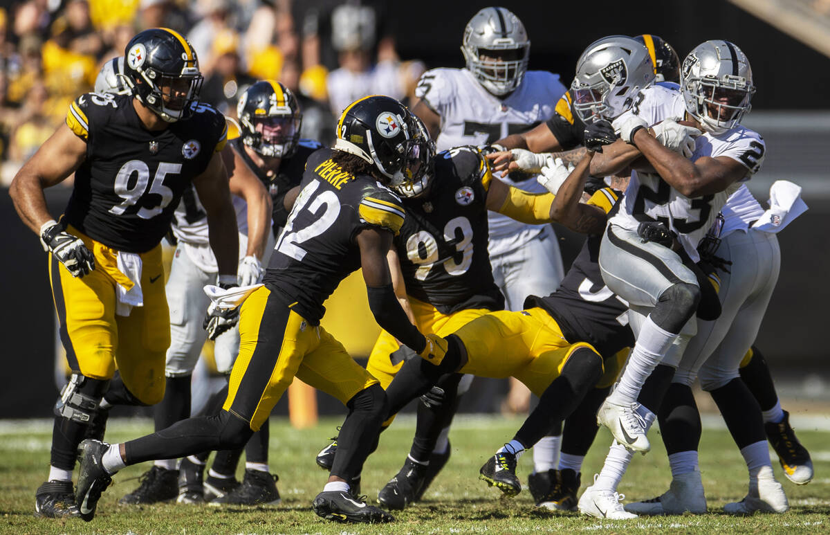 Raiders running back Kenyan Drake (23) breaks through a hole past Pittsburgh Steelers middle li ...