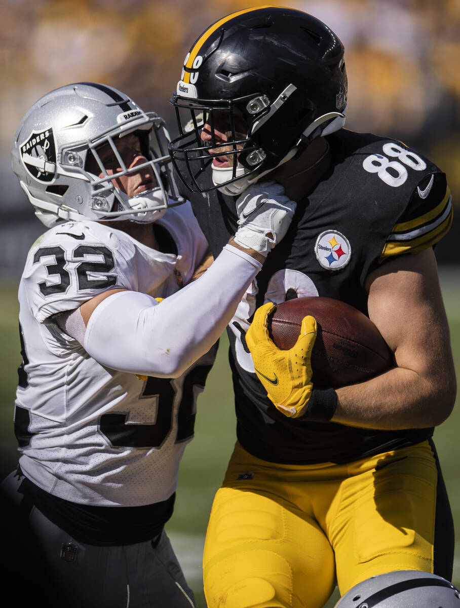 Raiders defensive back Dallin Leavitt (32) tackles Pittsburgh Steelers tight end Pat Freiermuth ...