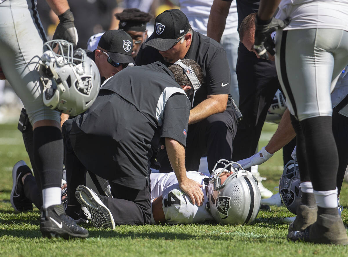 Raiders quarterback Derek Carr (4) remains down after getting hit as he threw a touchdown pass ...