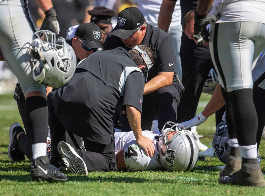 Raiders quarterback Derek Carr (4) remains down after getting hit as he threw a touchdown pass ...