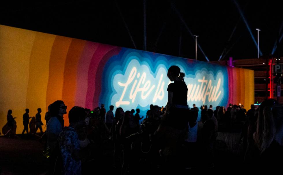 Attendees are silhouetted against a mural during the final day of the Life is Beautiful festiva ...
