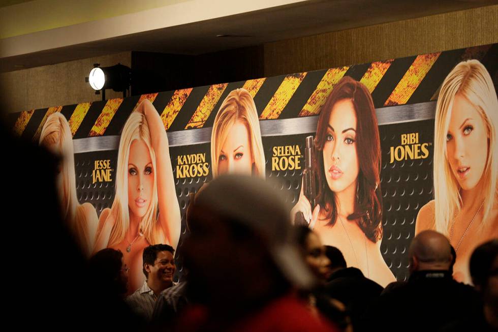 Crowds walk past a banner advertising adult film stars at AVN's Adult Entertainment Expo at the ...