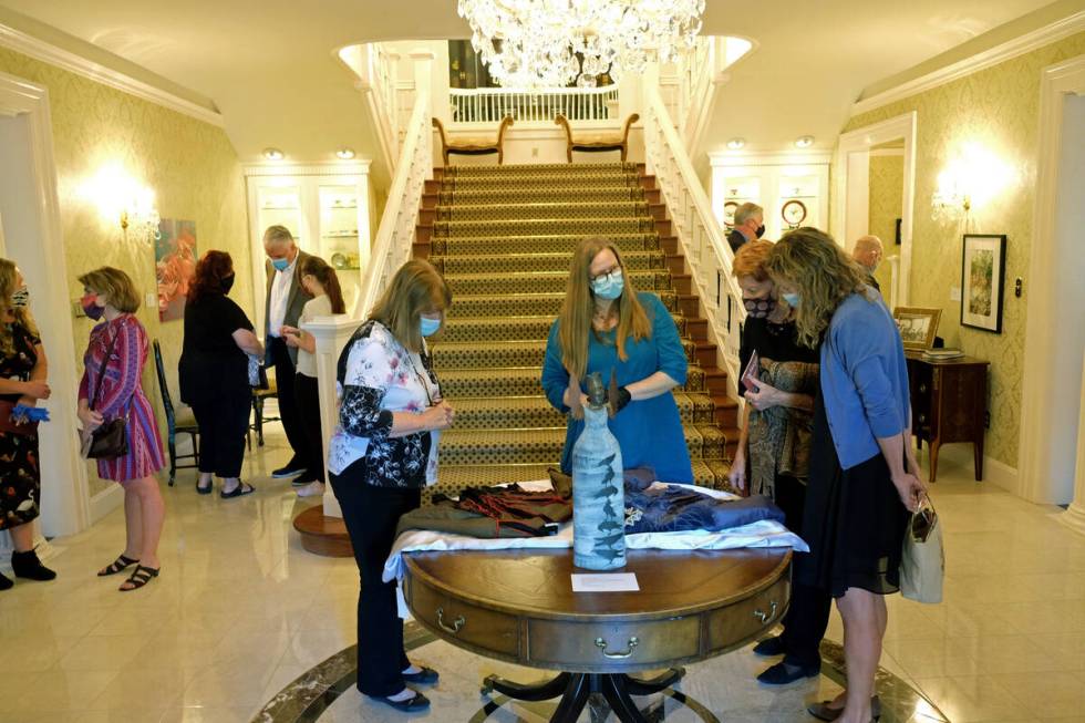 Visitors look at fabrics on display Monday as part of an exhibit in the governor's mansion in C ...