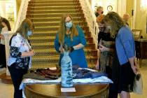 Visitors look at fabrics on display Monday as part of an exhibit in the governor's mansion in C ...