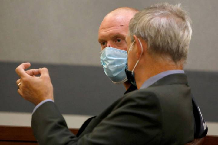 New Haven police officer Robert Ferraro, face to camera, listens to his attorney Gabriel Grasso ...