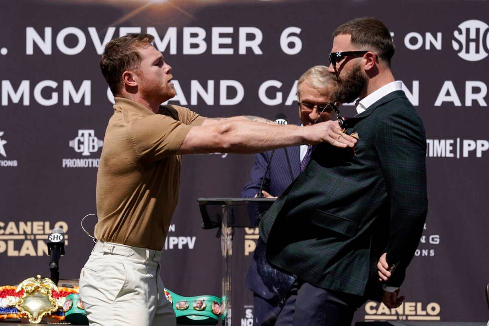 Unified WBC/WBO/WBA super middleweight champion Canelo Alvarez, left, shoves undefeated IBF Sup ...