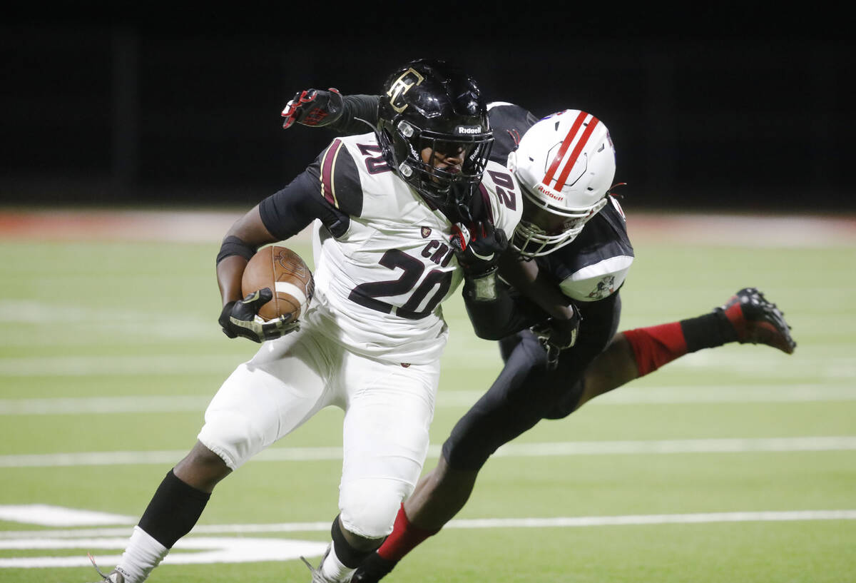 Faith Lutheran High School's Drais Bellamy (20) is tackled by Liberty High School's Landon Bell ...