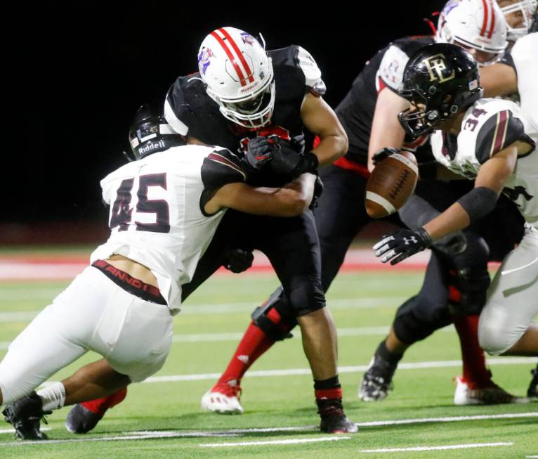 Liberty High School's Chad Kapanui (50) fumbles a ball against Faith Lutheran High School's De ...