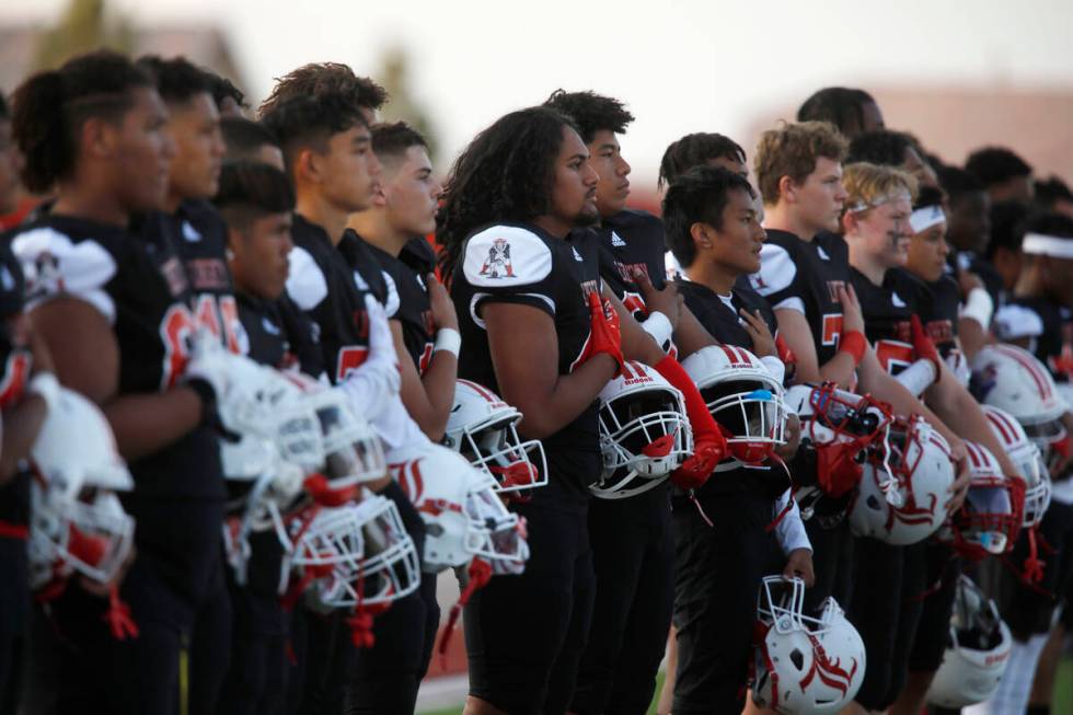 Liberty High School's players stand during the national anthem before a football game against F ...