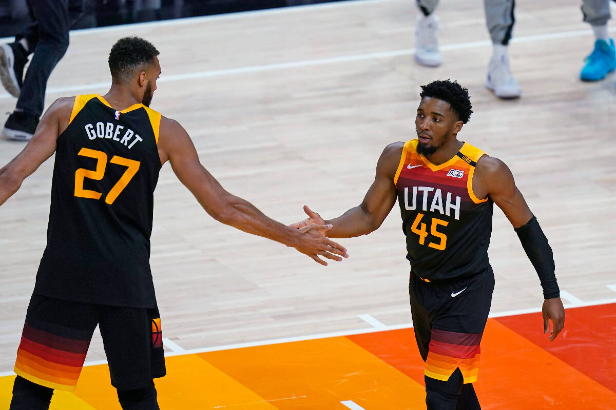 Utah Jazz's Rudy Gobert (27) congratulates Donovan Mitchell (45) after he scored against the Me ...