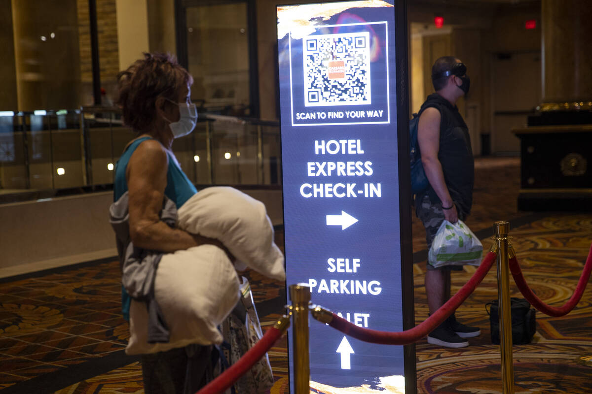 A sign directs guests to new machines that allow a self check-in at the Caesars Palace hotel-ca ...