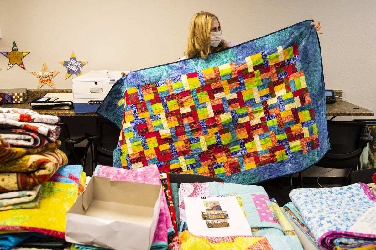 Tennille Pereira, director of the Vegas Strong Resiliency Center, shows a donated quilt created ...