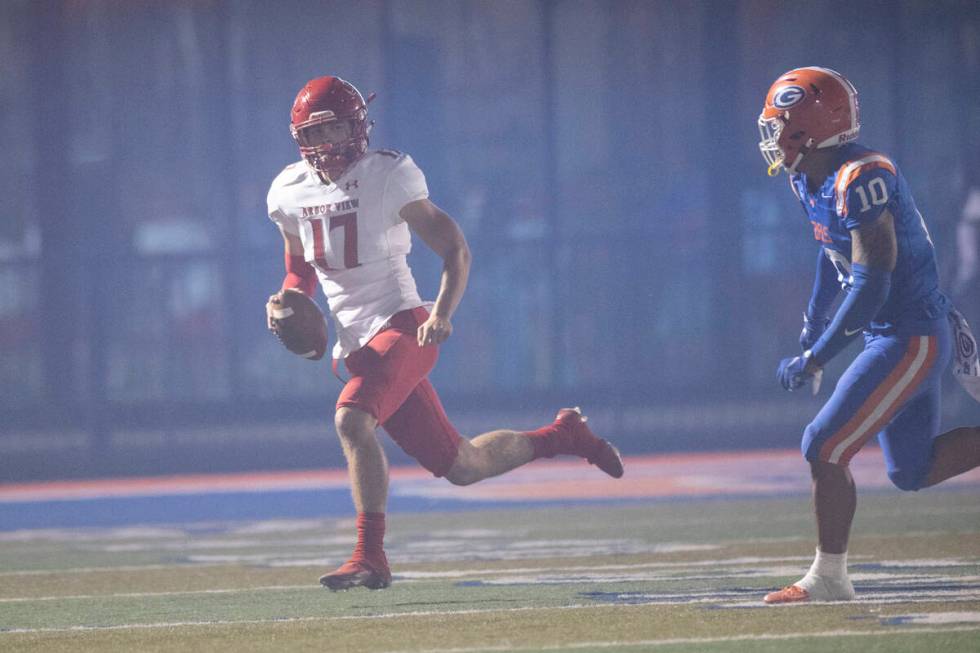 Arbor View's Kyle Holmes (17) is pressured out of bounds by Bishop Gorman's Palaie Faoa (10) du ...