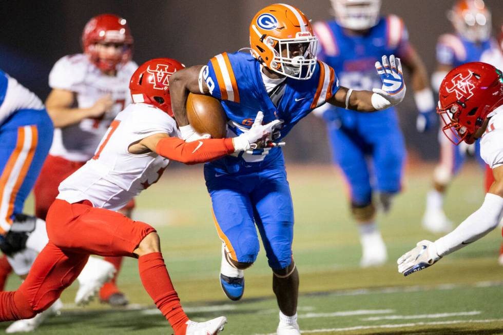 Bishop Gorman's Devon Rice (28) runs the ball before getting tackled by Arbor View's Aiden Powe ...