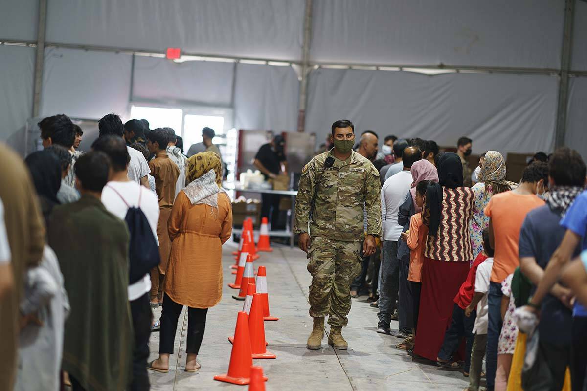 Afghan refugees line up for food in a dining hall at Fort Bliss' Doña Ana Village where they a ...