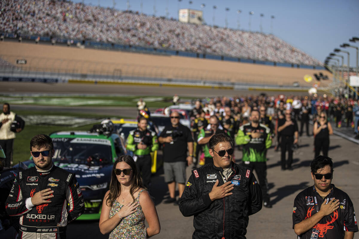 Pit crews, drivers and family listen to the national anthem before the start of the Alsco Unifo ...