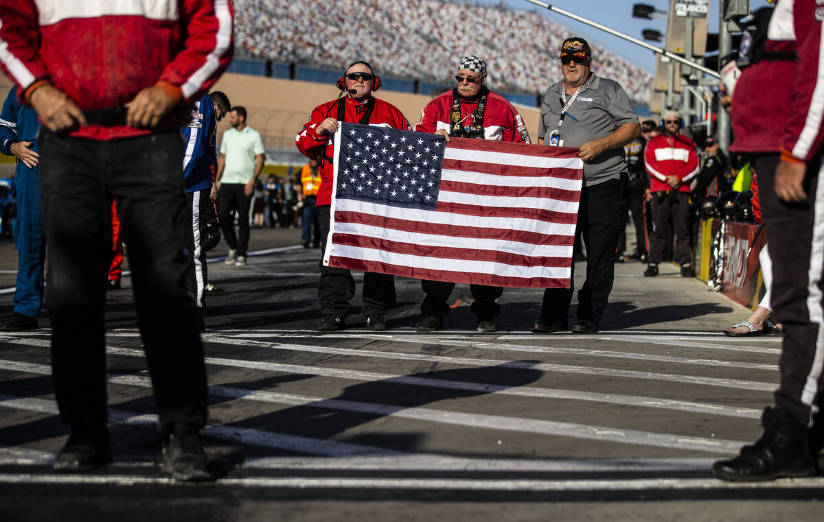 Race staff hold an American flag during the national anthem before the start of the Alsco Unif ...