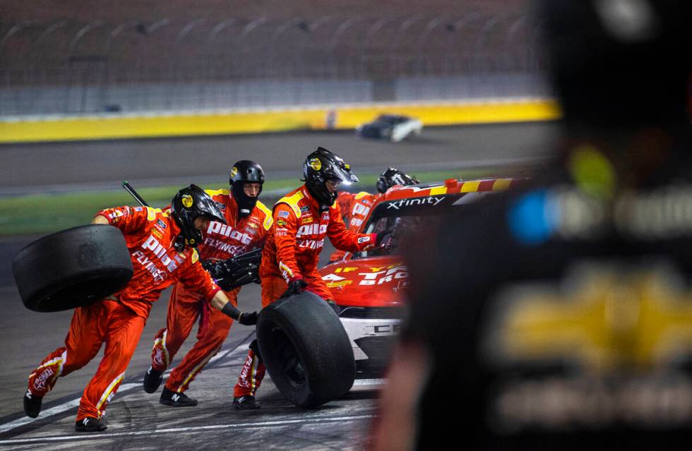 Pit crews work on a race car during the Alsco Uniforms 302 NASCAR Xfinity series race on Saturd ...