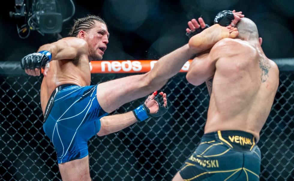 Brian Ortega, left, connects with a kick on Alexander Volkanovski in the fourth round during th ...