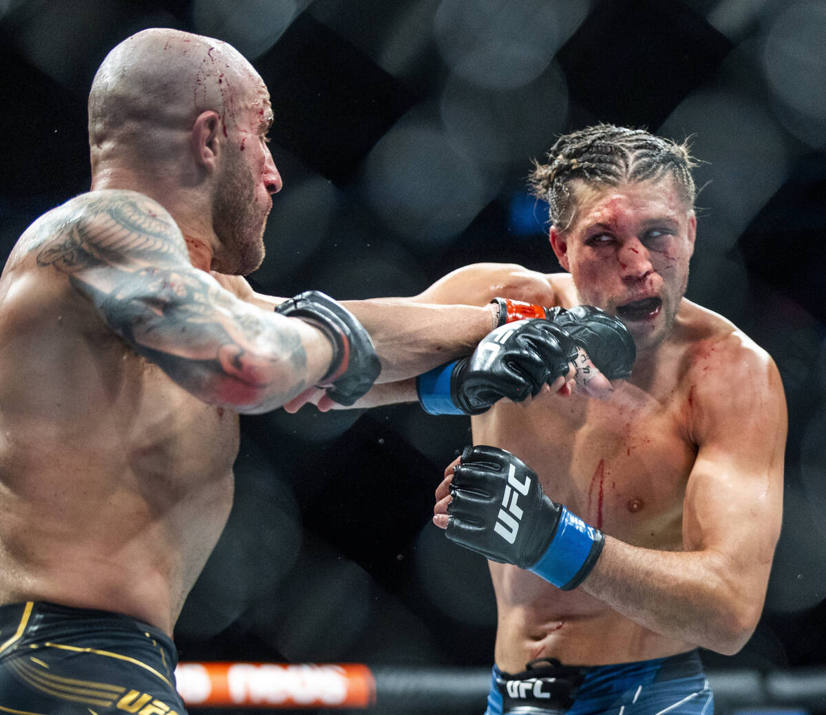 Alexander Volkanovski, left, punches Brian Ortega on the chin in the fifth round during their f ...